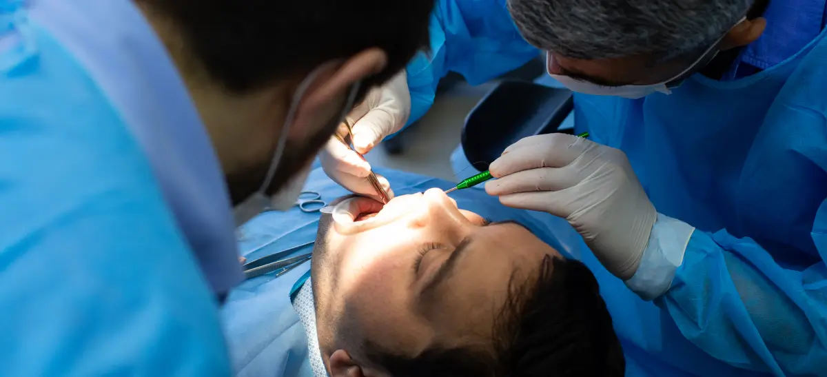Dentistas realizando atendimento de emergência odontológica em paciente