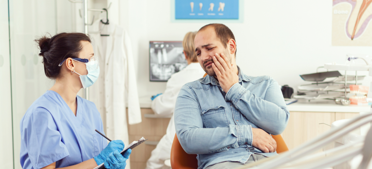 Homem em consulta no dentista para resolver problema com dente podre