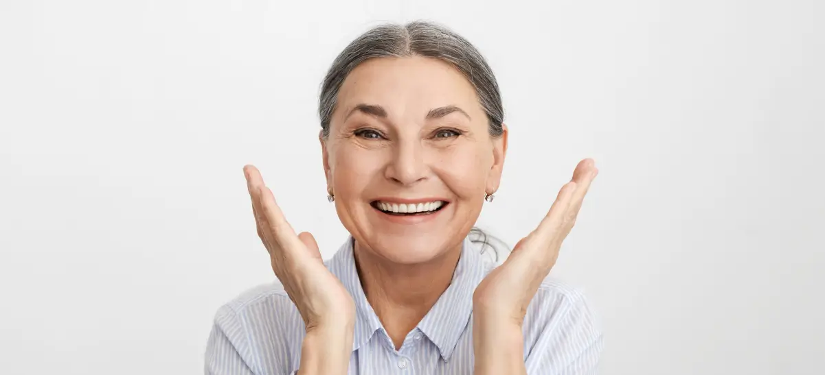Mulher idosa feliz com o sorriso após colocar dente provisório