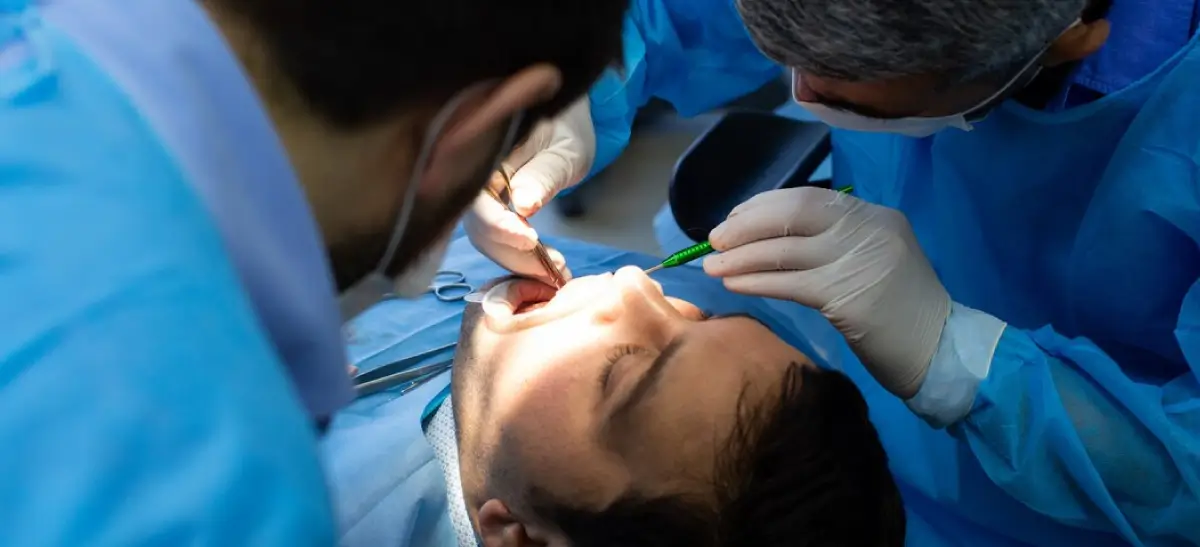 Cirurgião-dentista realizando procedimento de apicectomia em paciente