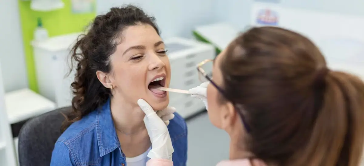 Dentista examinando a boca e a garganta de uma paciente