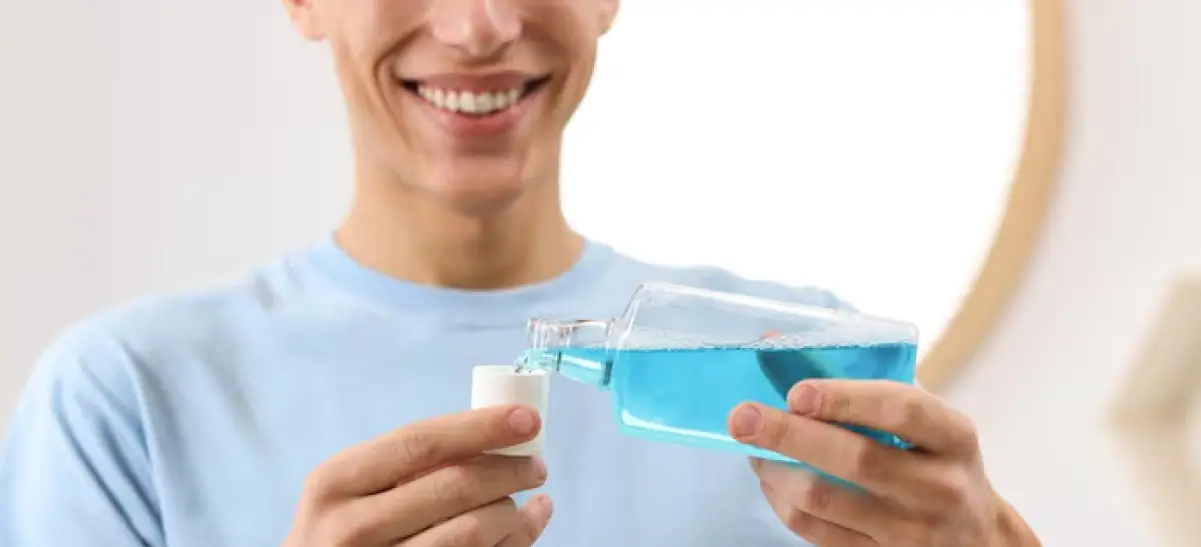 Jovem usando enxaguante bucal após escovar os dentes